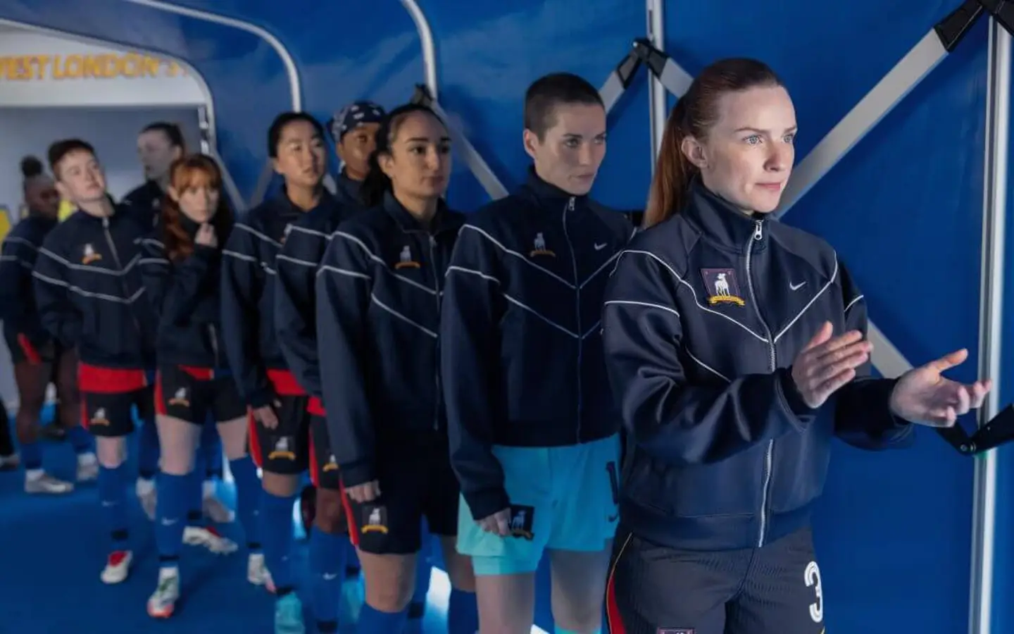 Cena do último episódio da 3ª temporada de Ted Lasso (So Long, Farewell), onde a equipe feminina do AFC Richmond se prepara para entrar em campo no Nelson Road, simbolizando o novo capítulo do clube liderado por Keeley Jones e Rebecca Welton.