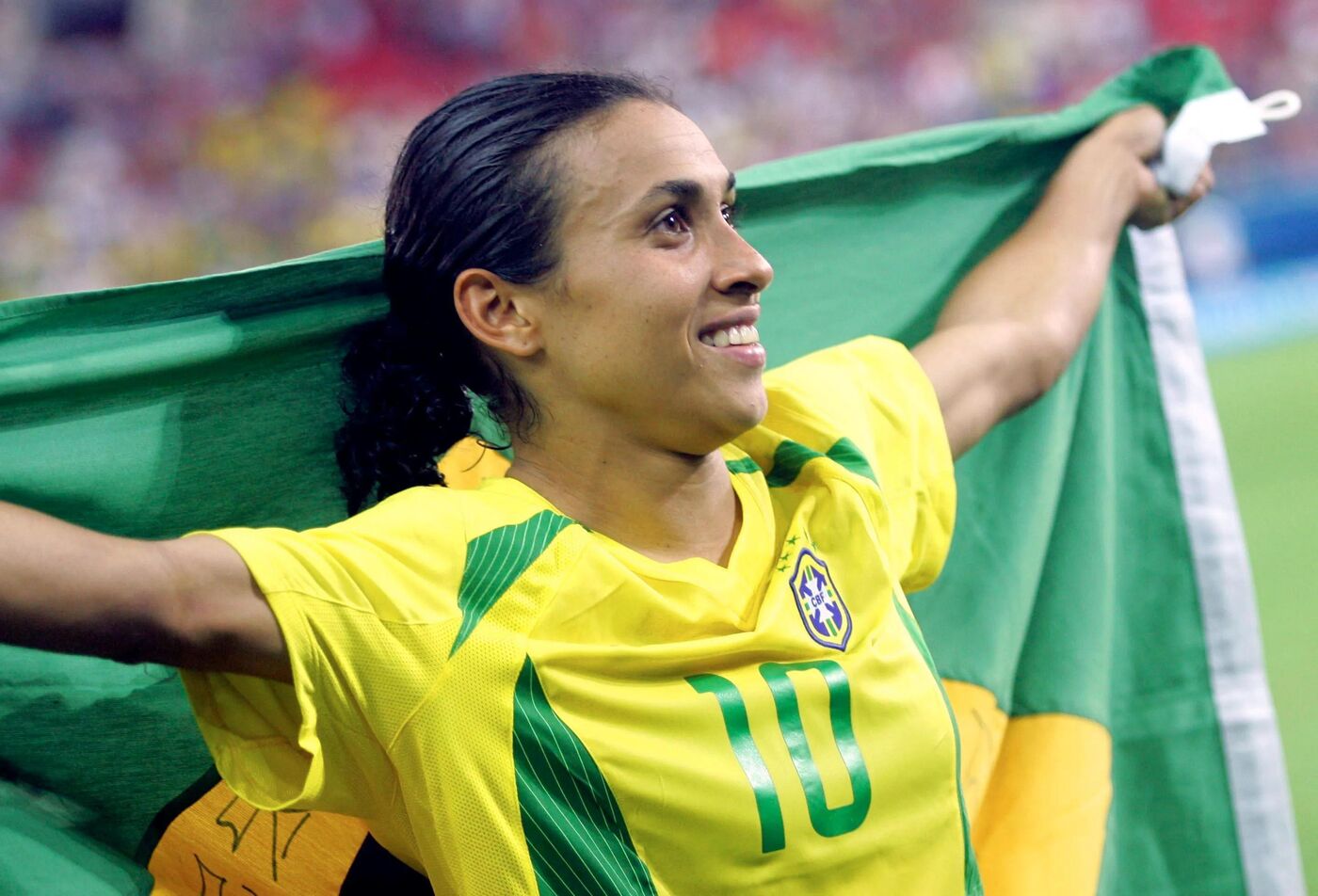 Marta celebra com a bandeira do Brasil durante os Jogos Olímpicos de Atenas, em 2004.