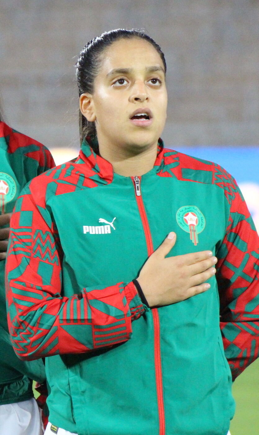 A atacante marroquina Sakina Ouzraoui Diki com a camisa da Seleção Marroquina de Futebol Feminino, atleta que representa as Leões do Atlas internacionalmente e atua no futebol europeu.