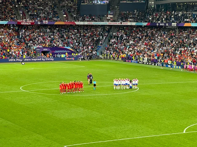 As duas seleções no círculo central durante a disputa de pênaltis, com o estádio cheio