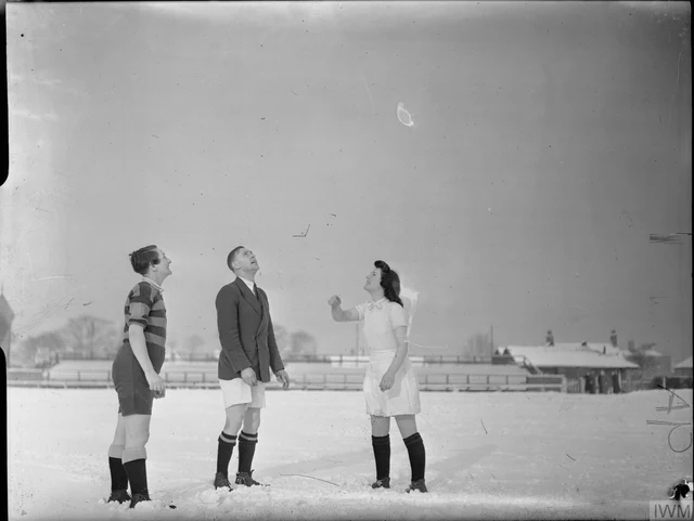 O sorteio antes do jogo: a capitã da A. V. Roe joga a moeda enquanto o árbitro e a capitã da Fairey observam, na neve